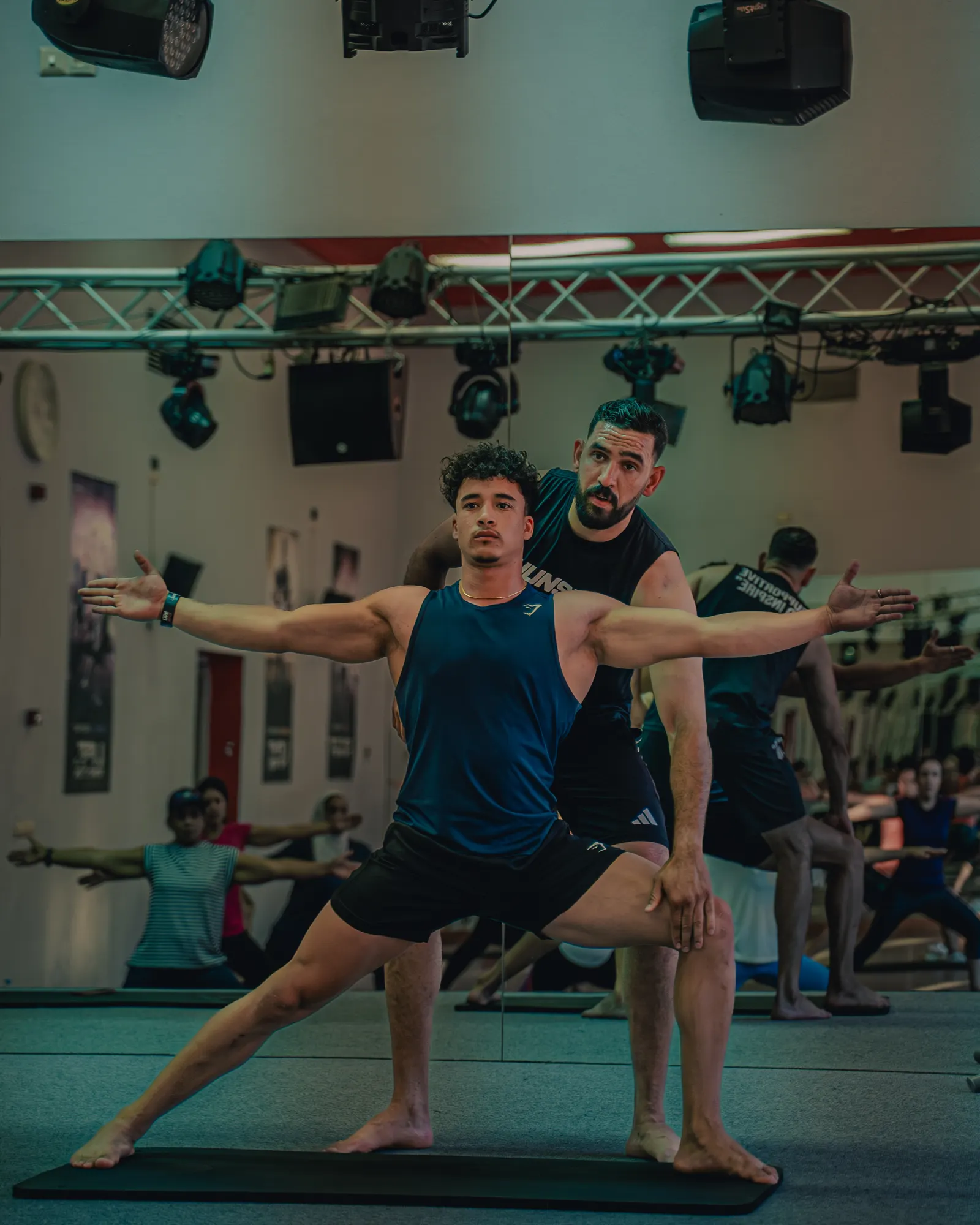 Coach adjusting a pose in a Les Mills Yoga class in Marrakech